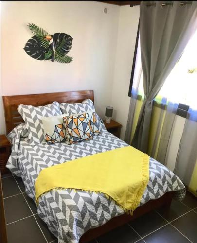 a bedroom with a bed with a yellow blanket at Côté Volcan in La Plaine des Cafres