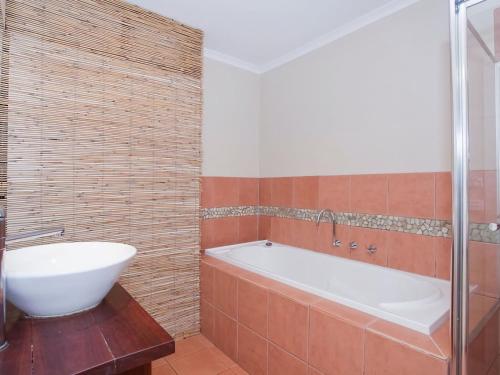 a bathroom with a bath tub and a sink at Great Ocean Retreat 43 in Torquay
