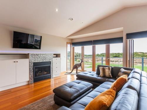a living room with a blue couch and a fireplace at Esplanade Frontage 219a in Torquay