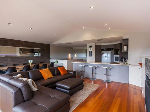 a living room with a brown couch and a bar at Esplanade Frontage 219a in Torquay