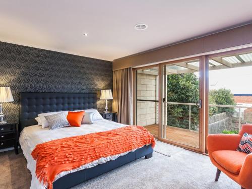 a bedroom with a bed and a sliding glass door at Esplanade Frontage 219a in Torquay