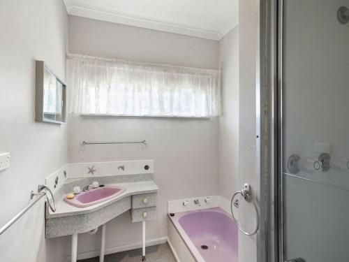 a bathroom with a pink sink and a tub at Coffey Court Cottage 2 in Torquay