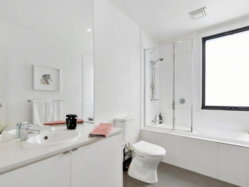 a white bathroom with a sink and a toilet at Coast Drive Beach and Golf 31 in Torquay