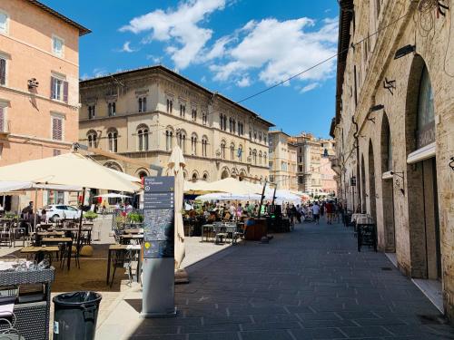 a city street with tables and chairs and buildings at Nima Oberdan House in Perugia