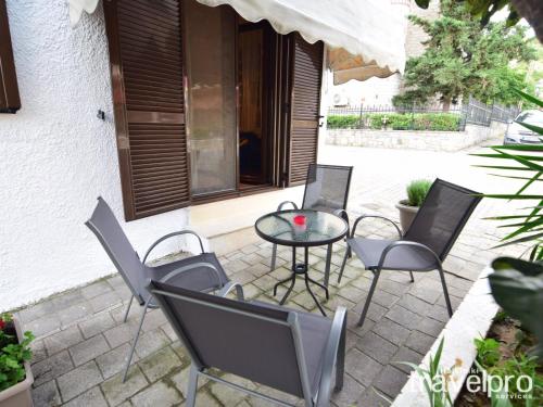 patio z krzesłami, stołem i oknem w obiekcie Summer Colours Home by RentalsPro- Kallithea Halkidiki w mieście Kallithea