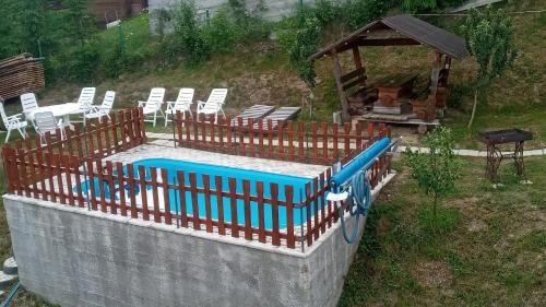 a swimming pool with chairs and a gazebo at Біля лісу Шале з двома спальнями in Slavske
