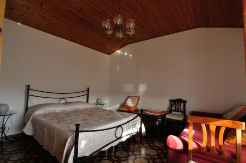 een slaapkamer met een bed en een stoel bij La casa di Silvia in Vallecchia