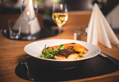a plate of food on a table with a glass of wine at Spa Hotel Härmä - Härmän Kylpylä in Ylihärmä