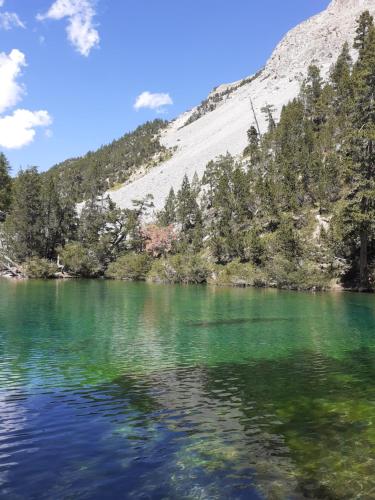a view of the emerald green water of a mountain lake at Le Bacchu Ber in Briançon