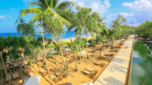 an aerial view of a beach with chairs and palm trees at Pandanus Beach Resort & Spa in Bentota