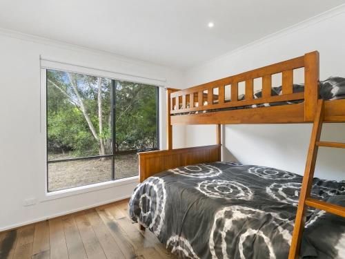 a bedroom with a bunk bed and a large window at Paringa 15 Anglesea Beach House in Anglesea