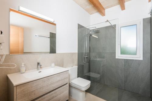 a bathroom with a shower and a sink and a toilet at Villa Calan Bosch Es Bruc in Cala'n Bosch
