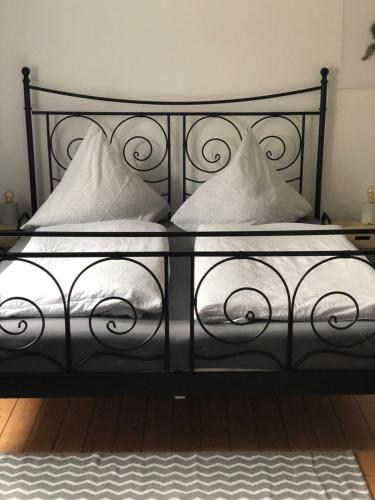 Una cama negra con almohadas blancas. en [E] ifeel home_ Adenau, en Adenau
