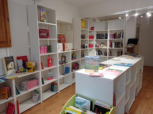 a room with white shelves filled with books at Maison Rives - Village du Livre de Montolieu in Montolieu