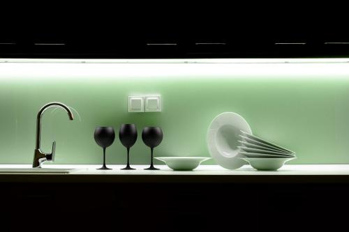 a counter with two spoons and a plate and a sink at BLACKHAUS Apartments in Thessaloniki
