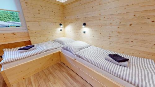 a room with two beds in a wooden cabin at Penzion Sabina in Vernár