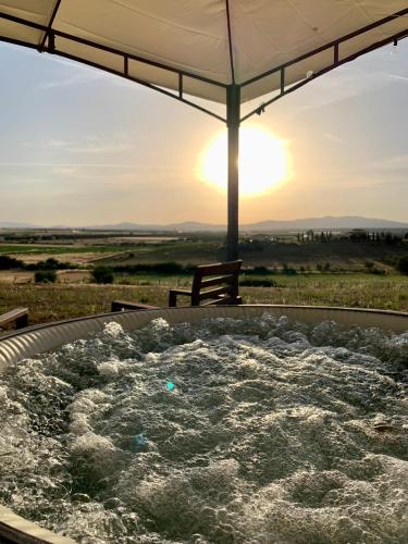 a hot tub with the sunset in the background at Il Poggio di Musignano in Musignano