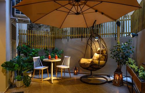 a patio with a swing and chairs and an umbrella at BLACKHAUS Apartments in Thessaloniki