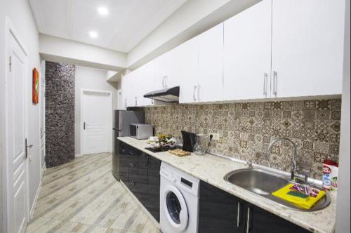 a kitchen with a sink and a washing machine at Leyla Apartments 1 in Baku