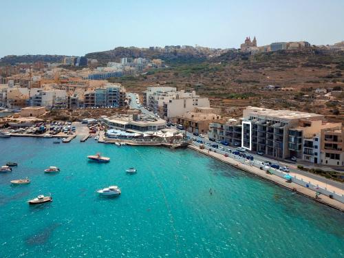 an aerial view of a harbor with boats in the water at Malta's Beachfront Apartment in Mellieha in Mellieħa