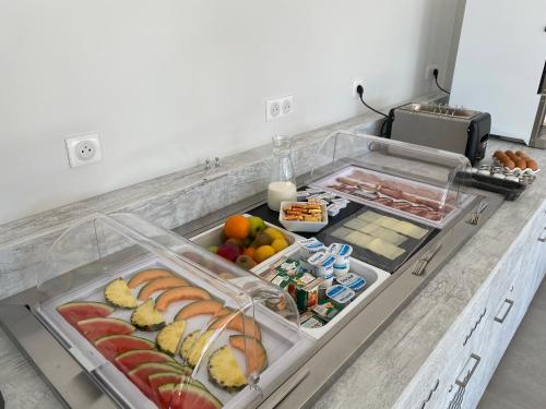 una barra de cocina con muchas bandejas de frutas y verduras en Hôtel L'Isula Marina en LʼÎle-Rousse