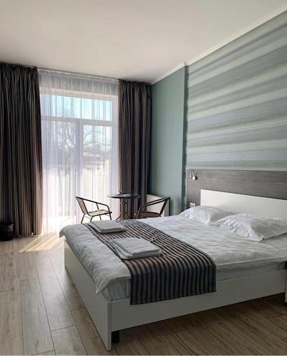 a bedroom with a bed and a large window at SeaLine Apart-Hotel in Odesa