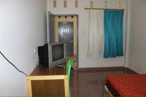 a small room with a television on a wooden table at Penginapan Syariah in Parit