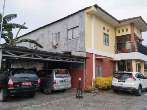 a group of cars parked in front of a building at Penginapan Syariah in Parit