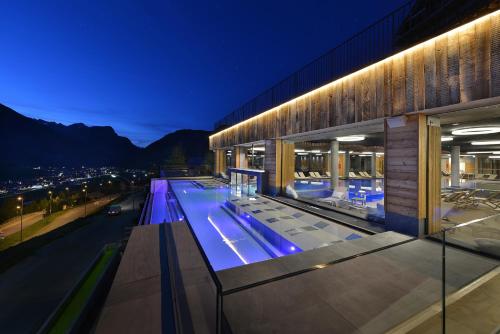 a building with a swimming pool at night at Alpen Resort Bivio in Livigno