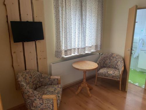 a room with two chairs and a table and a tv at Wertacher Hof in Oy-Mittelberg