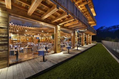 a restaurant with tables and chairs on a deck at Alpen Resort Bivio in Livigno