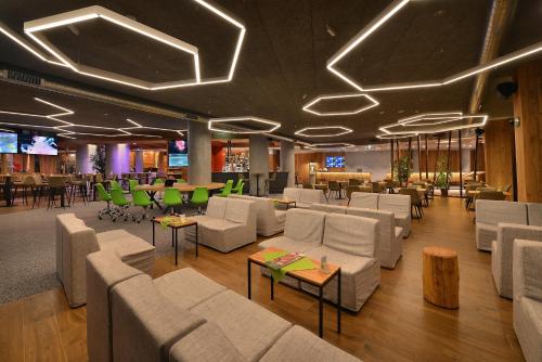 a lobby with couches and tables and a bar at Alpen Resort Bivio in Livigno