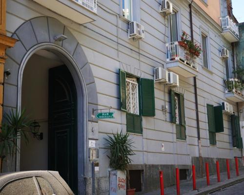 a building with green shuttered windows and a door at Duchessa Ravaschieri bed and breakfast in Naples