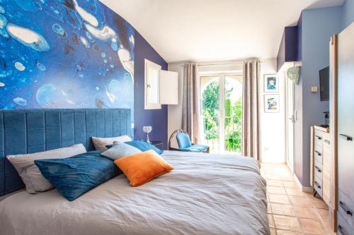 une chambre avec un lit avec une tête de lit bleue dans l'établissement Le Domaine des Mûriers - charme, chic, calme en Provence Côte d'Azur, à Plascassier