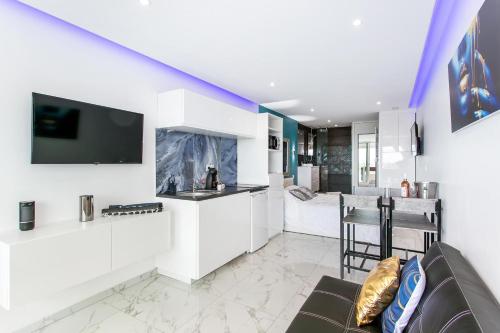 un salon avec un canapé et une cuisine dans l'établissement Village Naturiste R4N - Le Wallis Port Nature Coursive, au Cap d'Agde