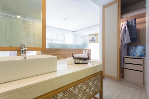 a bathroom with a sink and a mirror at Beach Walk Boutique Resort in Bangsaen