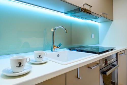 a kitchen with two coffee cups and a sink at BLACKHAUS Apartments in Thessaloniki