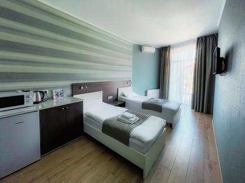 SeaLine Apart-Hotel في أوديسا: غرفة بسرير ومطبخ مع مايكرويف
