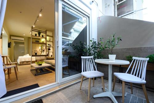 un patio con tavolo e sedie e un soggiorno di BLACKHAUS Apartments a Salonicco