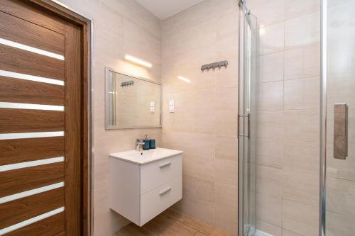 a bathroom with a sink and a shower at Apartament Perła in Ustka
