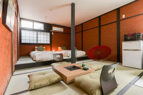 a bedroom with two beds and a table and chairs at NAKAZ Machiya , Osaka Umeda in Osaka
