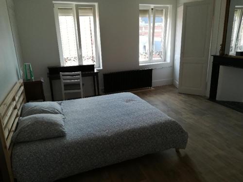 um quarto com uma cama e duas janelas em Bruneval lodge em Dunkerque