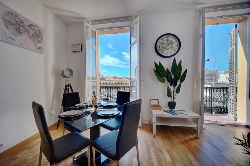 une salle à manger avec une table, des chaises et une horloge dans l'établissement Le ART - 500m des plages - Clim - Verrière Côte d'Azur, à Cannes