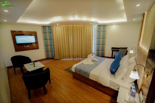 a hotel room with a bed and a table at Abhilashi Residency & Spa - Centrally Heated & Air Cooled in Manāli