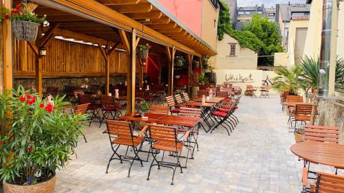 a patio with tables and chairs in a restaurant at Hotel Restaurant Unikat in Zeltingen-Rachtig