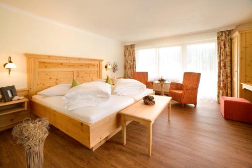 a bedroom with a large bed with a wooden headboard at Hotel Natur-Landhaus Krone in Maierhöfen