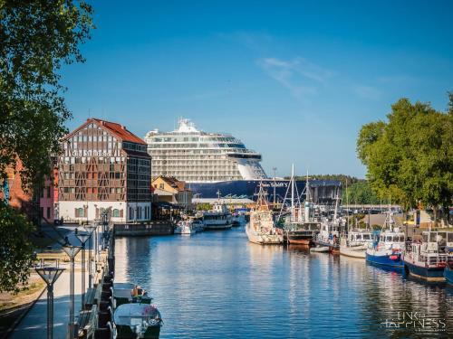 un navire de croisière est amarré dans un port avec des bateaux dans l'établissement No.4 Apartment Link-To-Happiness, à Klaipėda