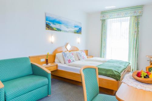 - une chambre avec un lit et une chaise bleue dans l'établissement Hotel garni Weberhäusl, à Strobl