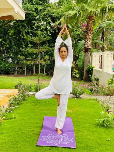 a woman doing a yoga pose on a yoga mat at Yog Niketan By Sanskriti in Rishīkesh