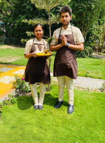 a man and a woman holding a plate of food at Yog Niketan By Sanskriti in Rishīkesh